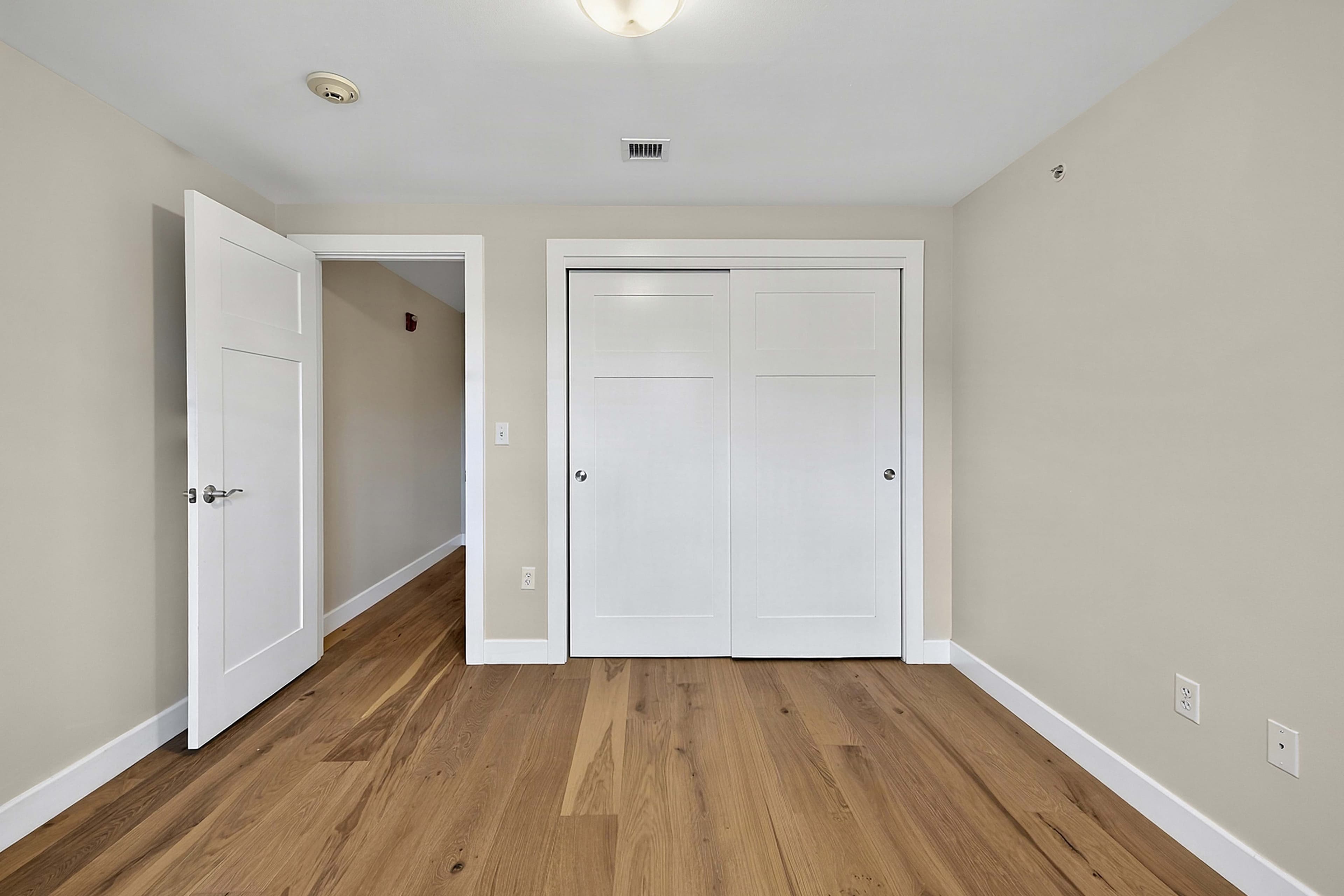 Bedroom viewed toward its closet and doorway
