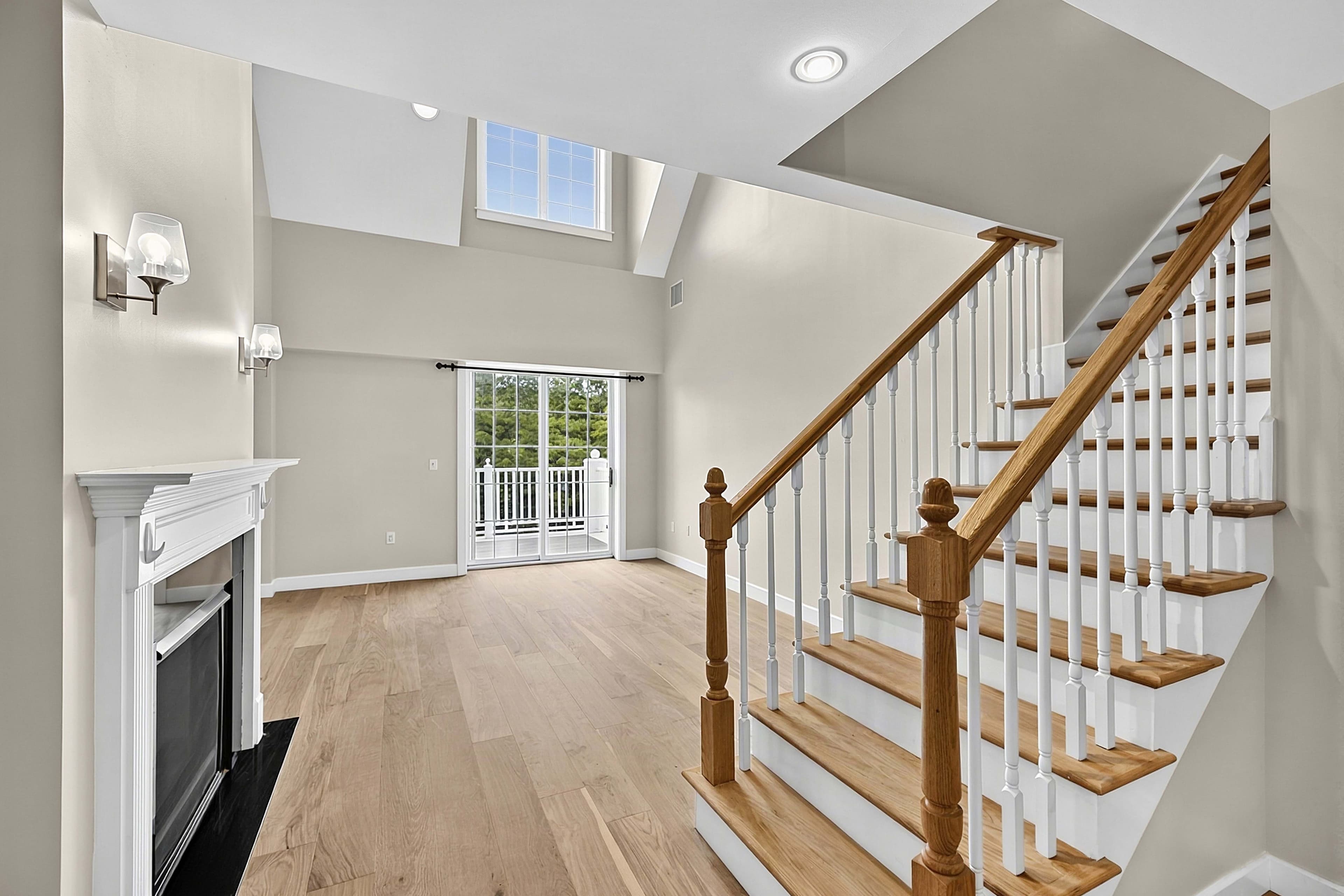 Double-height living room with a fireplace and staircase
