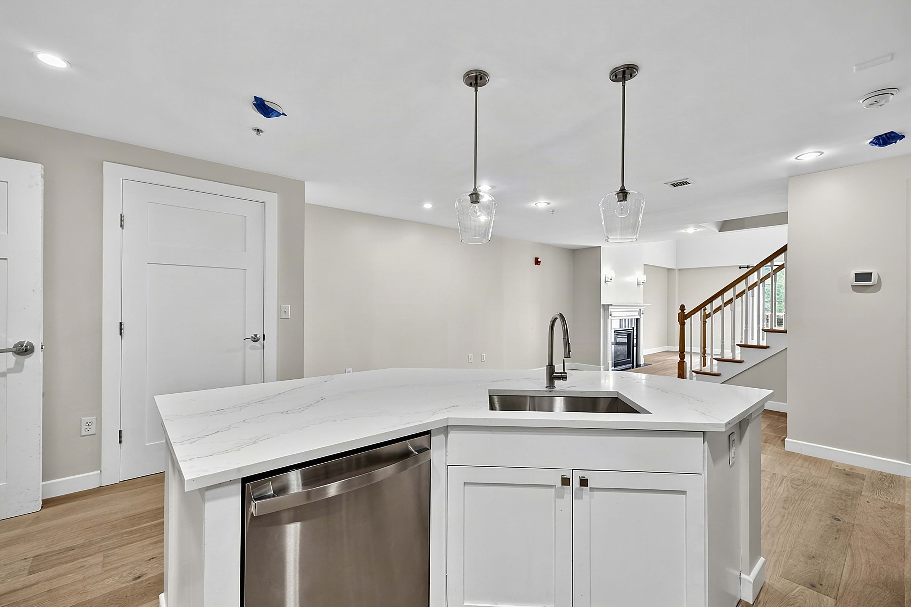 Kitchen sink and breakfast bar viewed toward the apartment entrance